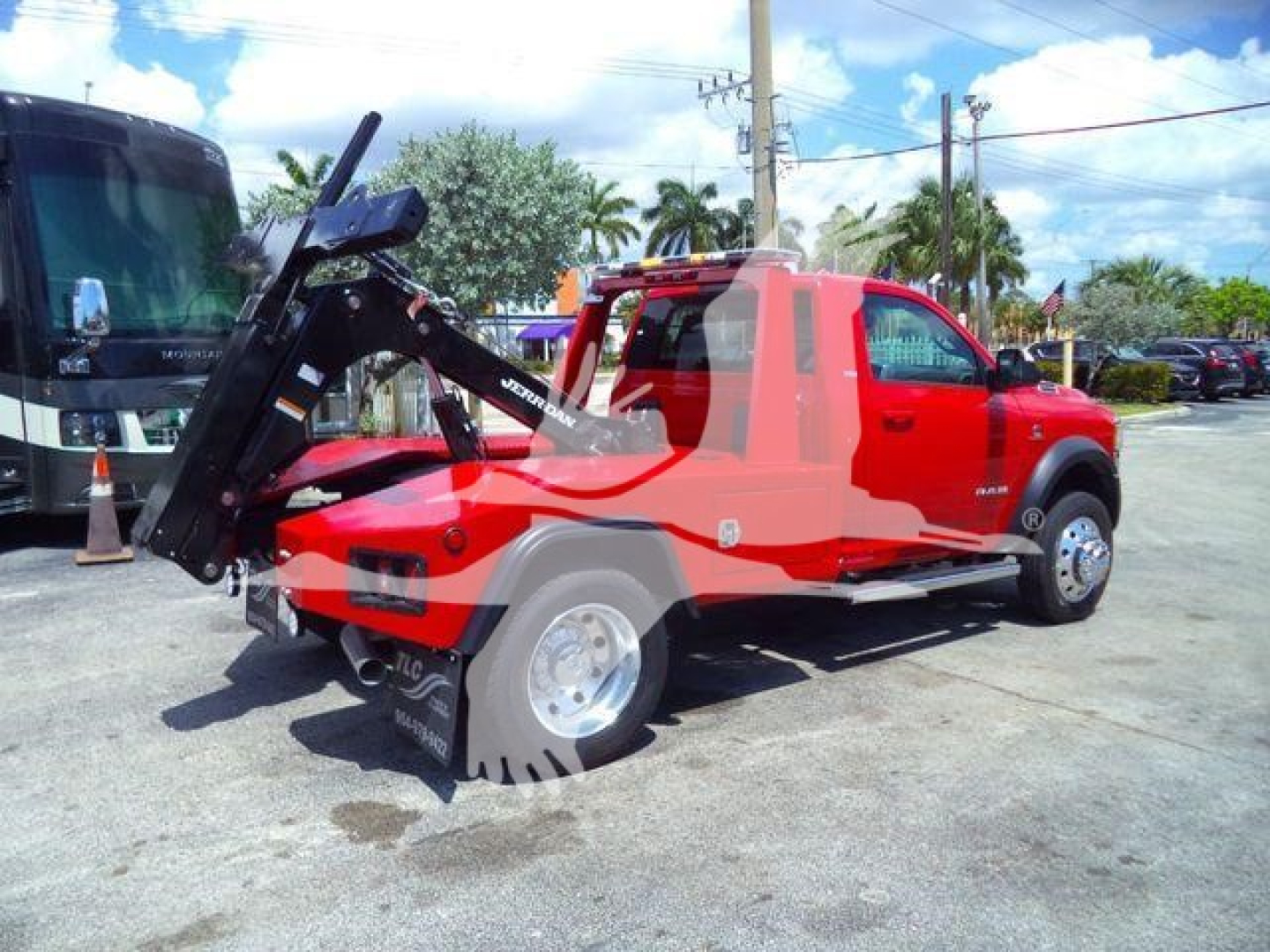 Ram 4500 tow truck with oversized front mount winch, red body, black control arm, and chrome wheels. Stock number REDRAM4500NGS visible in image.