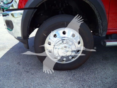 Front wheel and chrome hubcap of a red Ram 4500 truck with black tire and fender, visible stock wheel area.