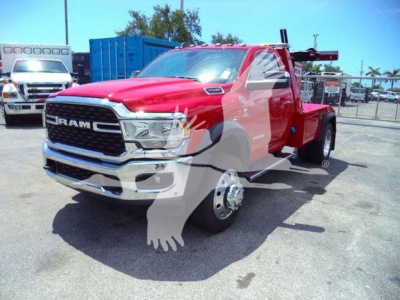 Ram 4500 tow truck with red cab and flatbed in a dealership lot, front grille with RAM emblem, chrome bumper, large side mirrors, stock number REDRAM4500NGS.