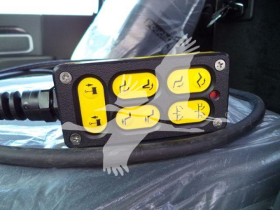 Winch controller panel with yellow labeled buttons and cable in view, mounted in a vehicle interior.