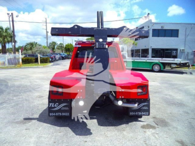 Ram 4500 truck rear view with a large overhead winch crane attachment and a red body in a dealership lot