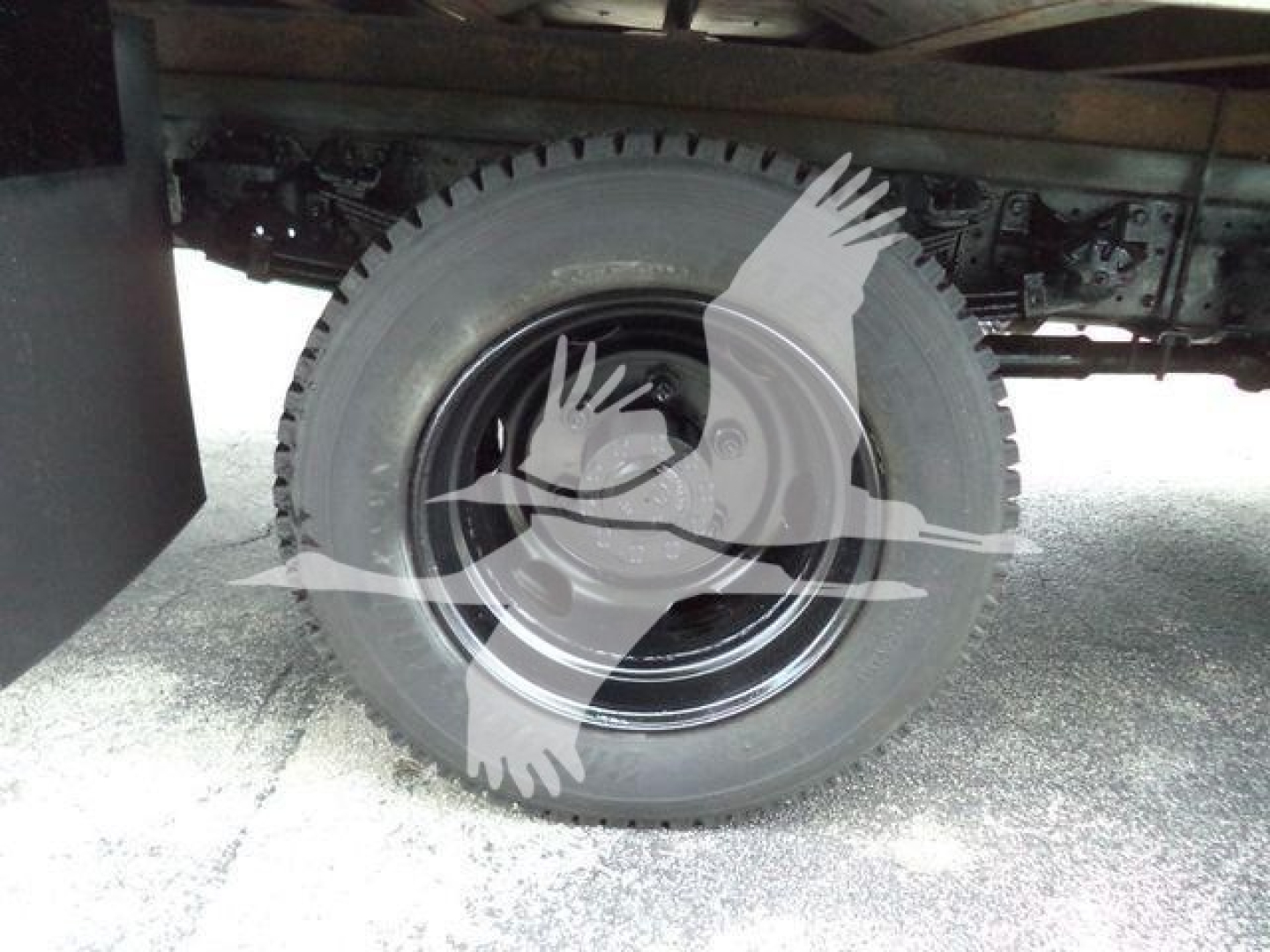 Rear wheel and undercarriage of a 2020 Hino truck showing solid black steel wheel and tire with surrounding chassis and suspension components.