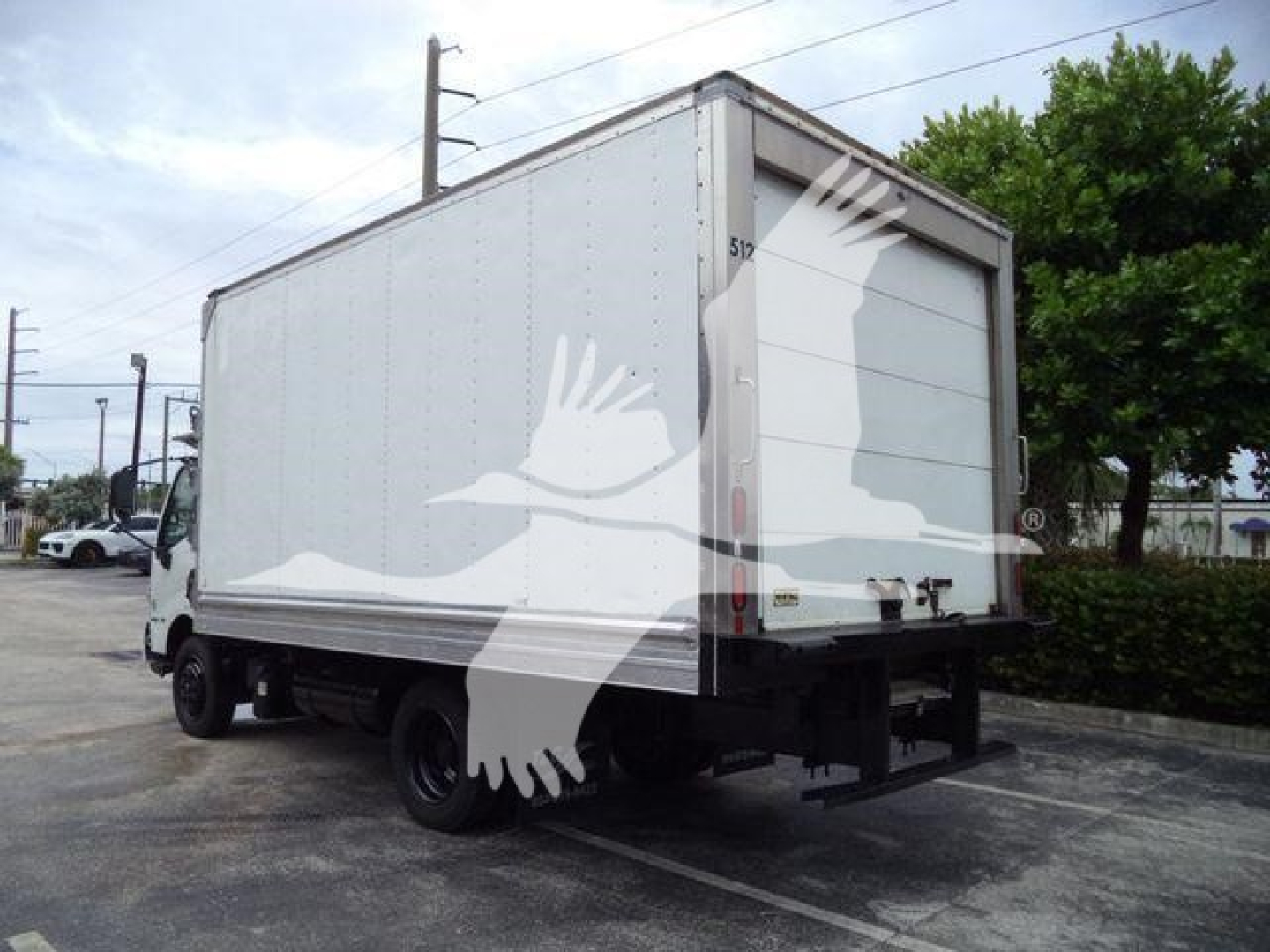 Refrigerated box truck rear-left view showing rear doors, undercarriage, and Hino 195 chassis.