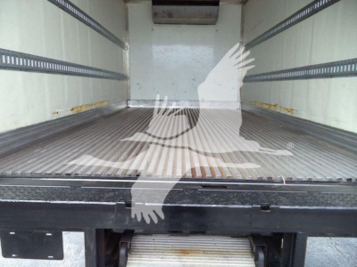 Truck bed interior of a refrigerated 2020 Hino 195 showing empty cargo area and side rails.
