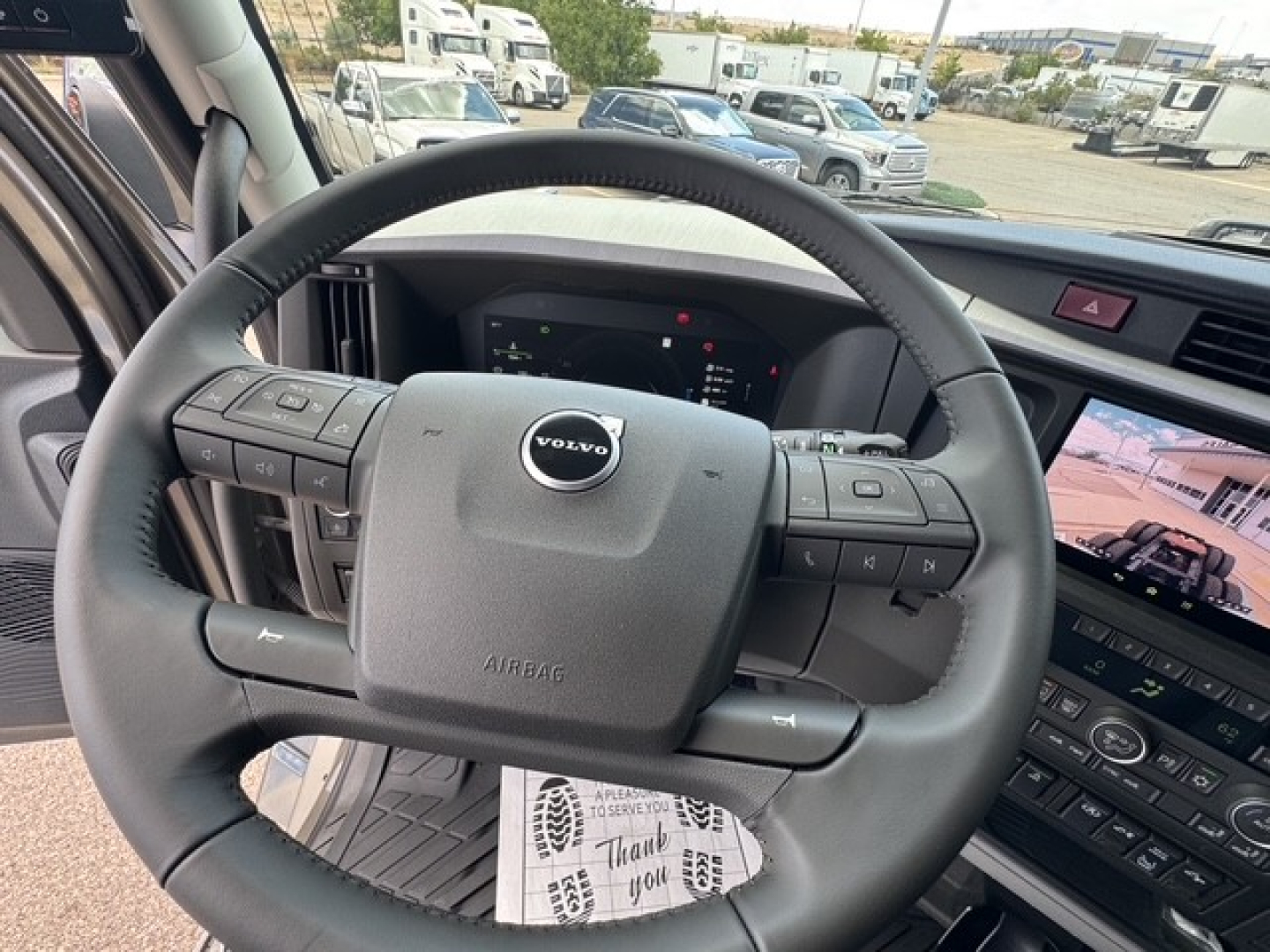 Volvo VNL truck steering wheel and dashboard view showing center console and digital gauges.