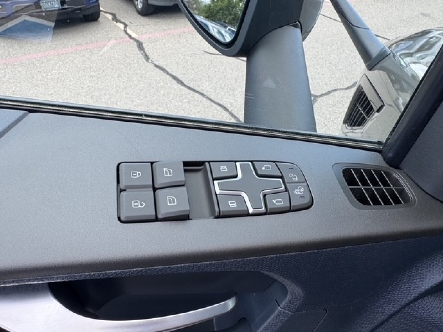 Interior close-up of Volvo VNL64T860 door panel with window/lock control switches visible.