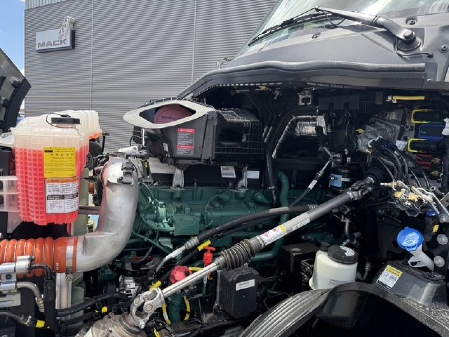 Volvo VNL64T860 truck engine bay view showing coolant reservoir and engine components.