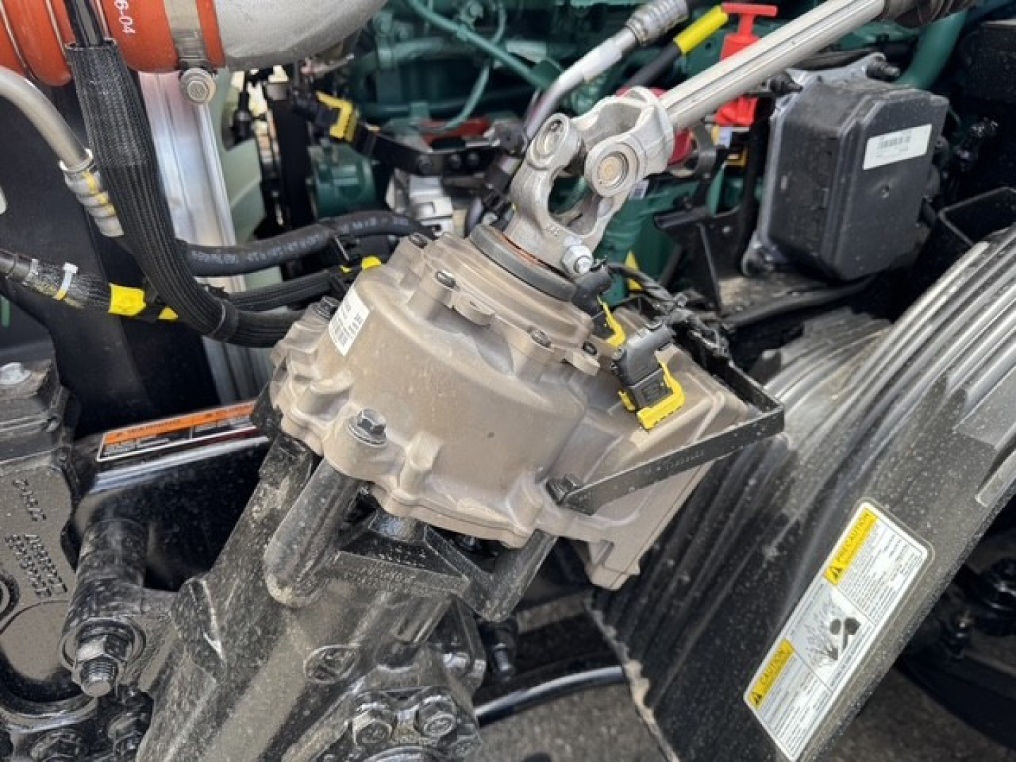 Volvo engine bay showing steering pump and belt assembly with hoses and electrical connectors.