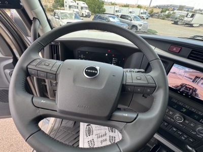 Volvo VNL truck steering wheel and dashboard view showing center console and digital gauges.