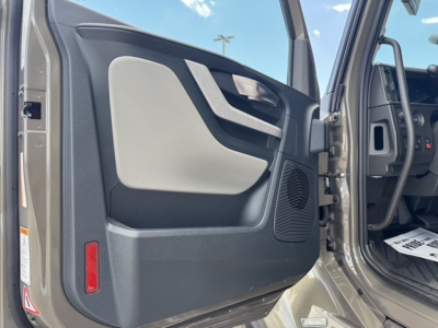 Volvo VNL64T860 truck interior door panel view showing beige armrest and control area.