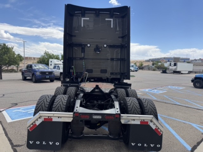  Volvo VNL64T860 truck rear view showing fifth wheel, dual rear axles, and mud flaps with Volvo branding. Clear sky and dealership lot in background.