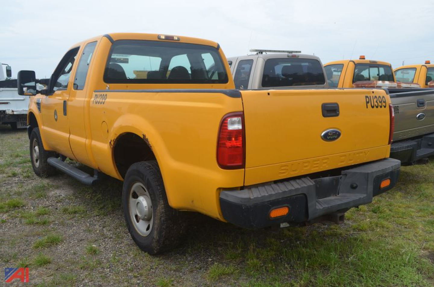 Yellow Ford F-250 Super Duty extended cab pickup truck rear view with tailgate and spare tire area in focus.