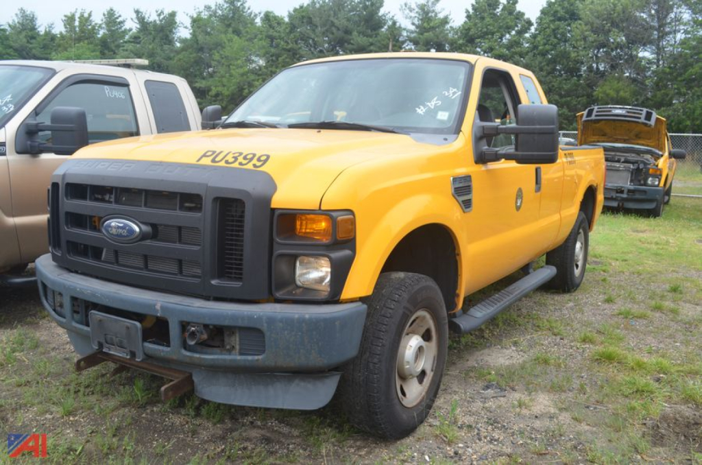 Ford F-250 Super Duty pickup truck in yellow, extended cab, front view, with bumper and grille, parked on grass.