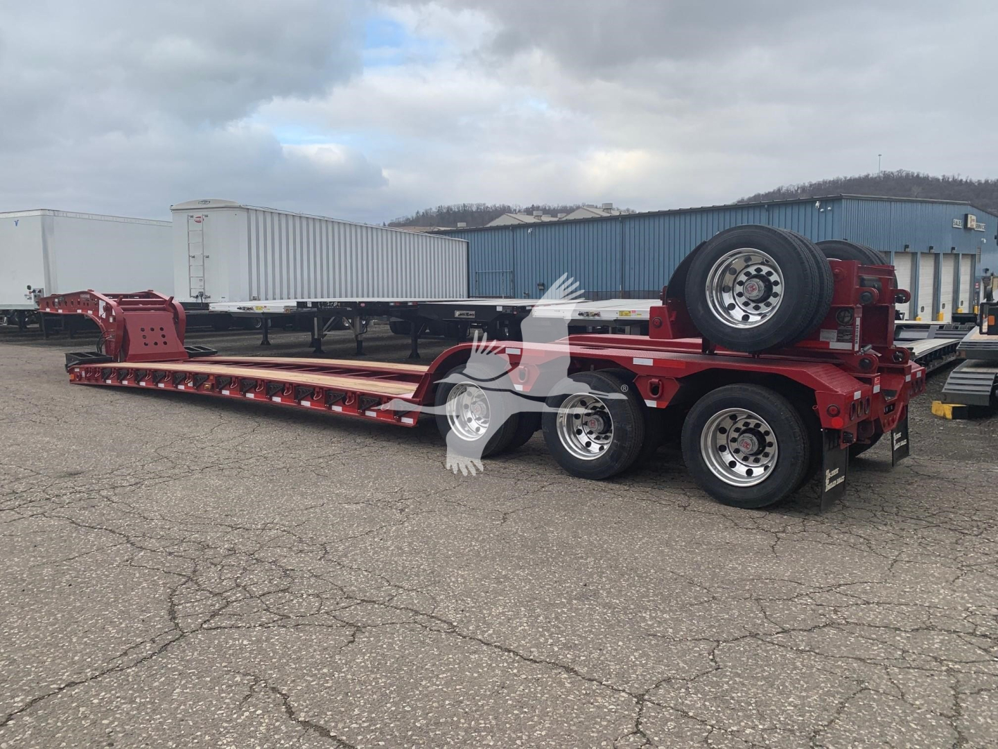 Fontaine 55LCC lowboy trailer with dual rear axles, red paint, spare tire mounted on rear, long flatbed with gooseneck design.
