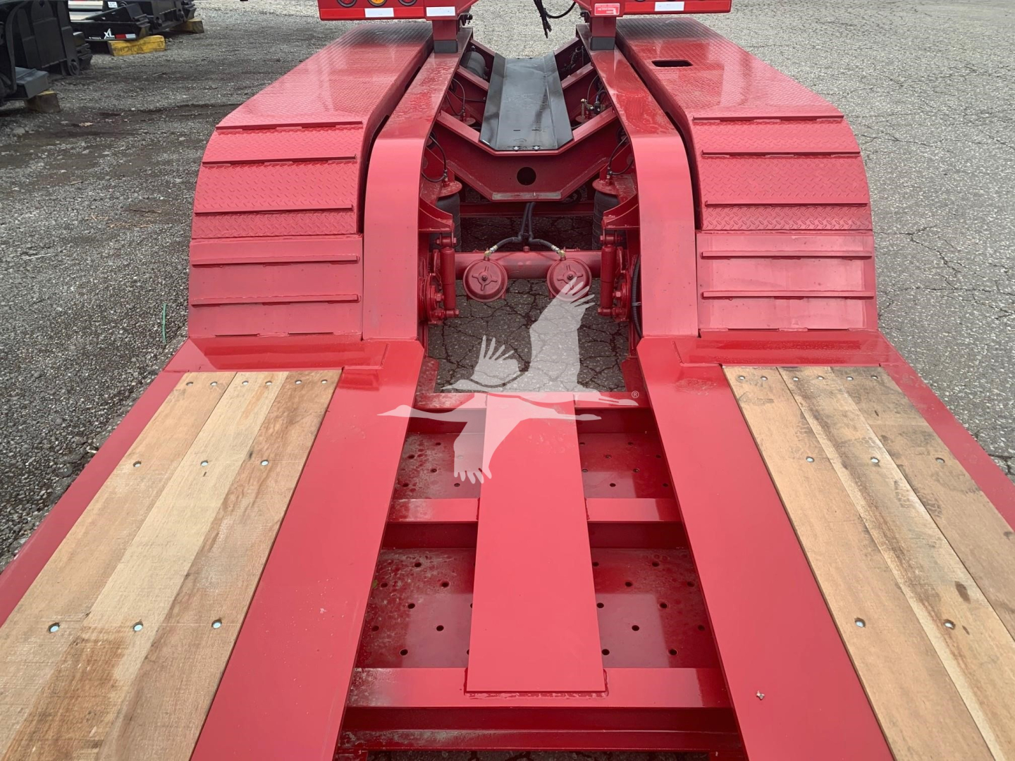 Fontaine 55Lcc lowboy trailer frame showing red chassis and wooden deck sections.
