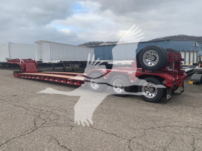 Fontaine lowboy trailer 55Lcc showing long flatbed with two-axle front and triple-axle rear, red frame, spare tire mounted at front.