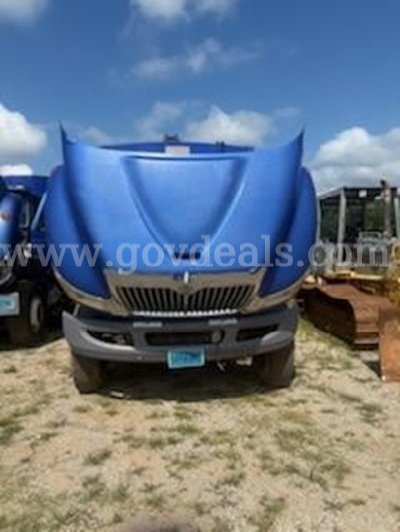 Truck hood of a 2011 International 4400 with blue hood, front grille, and bumper visible; watermarked image showing truck in a lot.