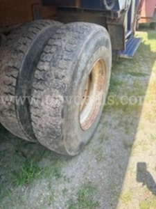 Tandem rear tires of a used 2011 International 4400 truck with dirt on tires and wheel well visible.