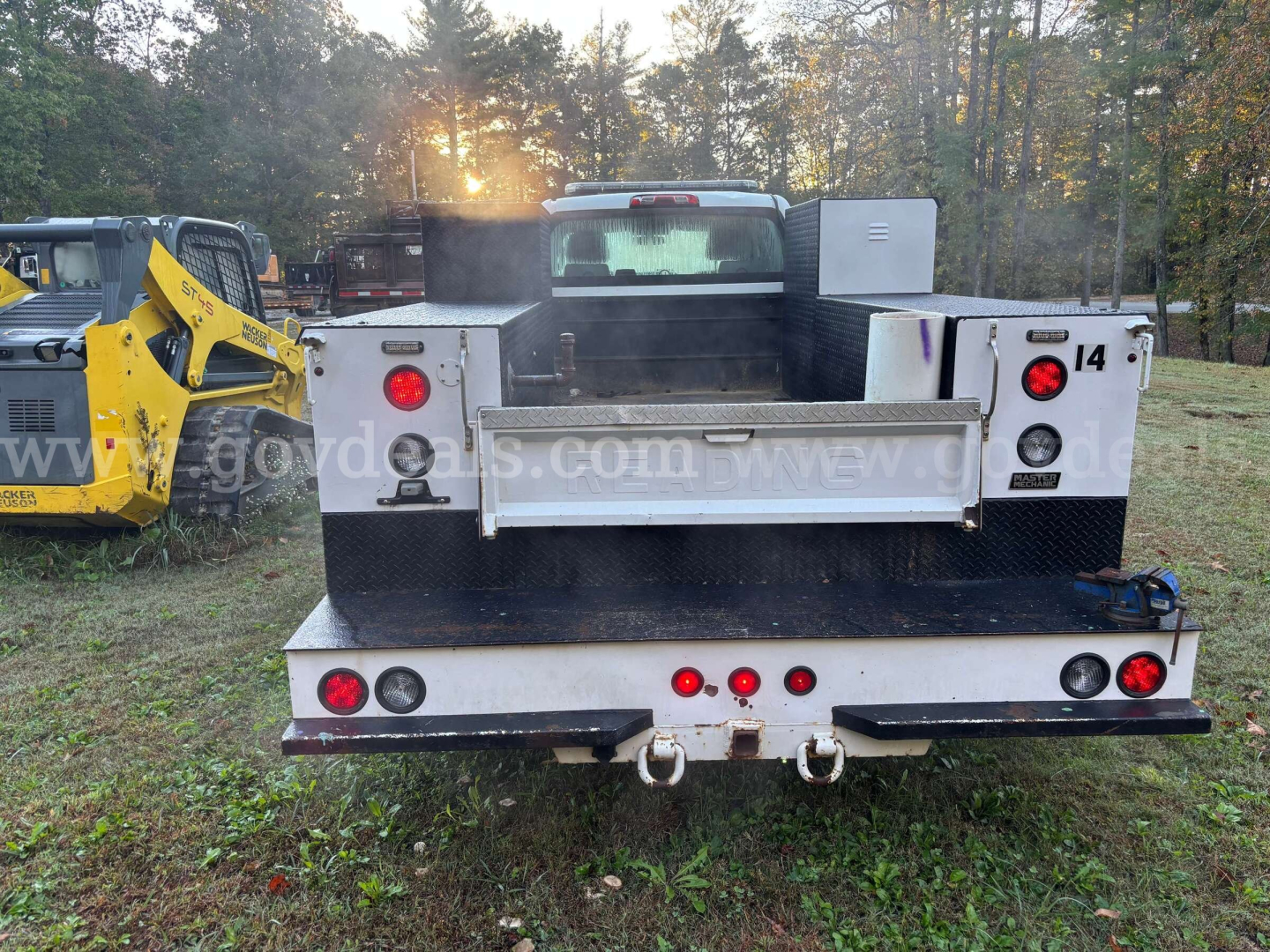 Truck bed of a 2020 International CV515 service/utility truck seen from rear, flatbed with silver metal toolbox and rear lights.