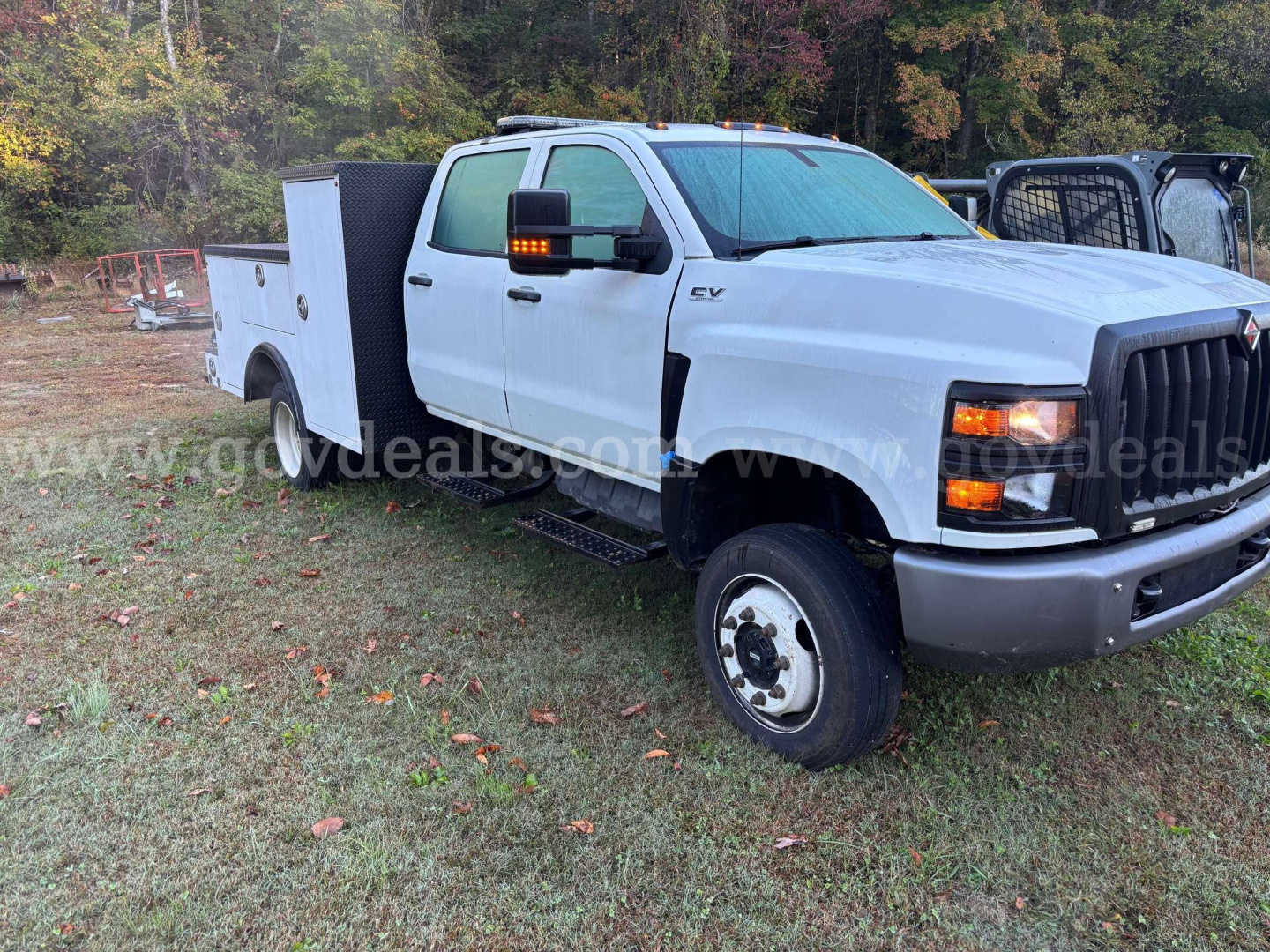 Service/utility truck cab front-right view showing 2020 International CV515, utility bed with compartments, VIN 1HTKTSWM4LH368969 visible on tag