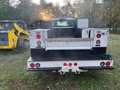 Truck bed of a 2020 International CV515 service/utility truck seen from rear, flatbed with silver metal toolbox and rear lights.