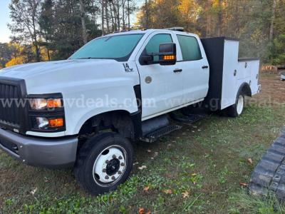 White 2020 International CV515 service/utility truck with utility toolbox, dual rear wheels, and gooseneck hitch visible; front grille and headlights clear.
