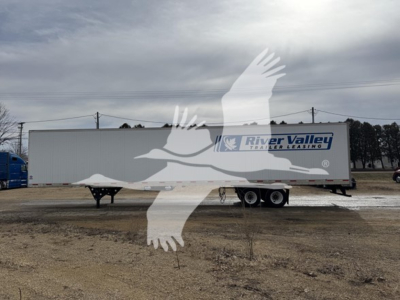 Trailer side of a used 2017 utility dry van with River Valley trailer leasing logo on the side and a white cab-over truck in the background.