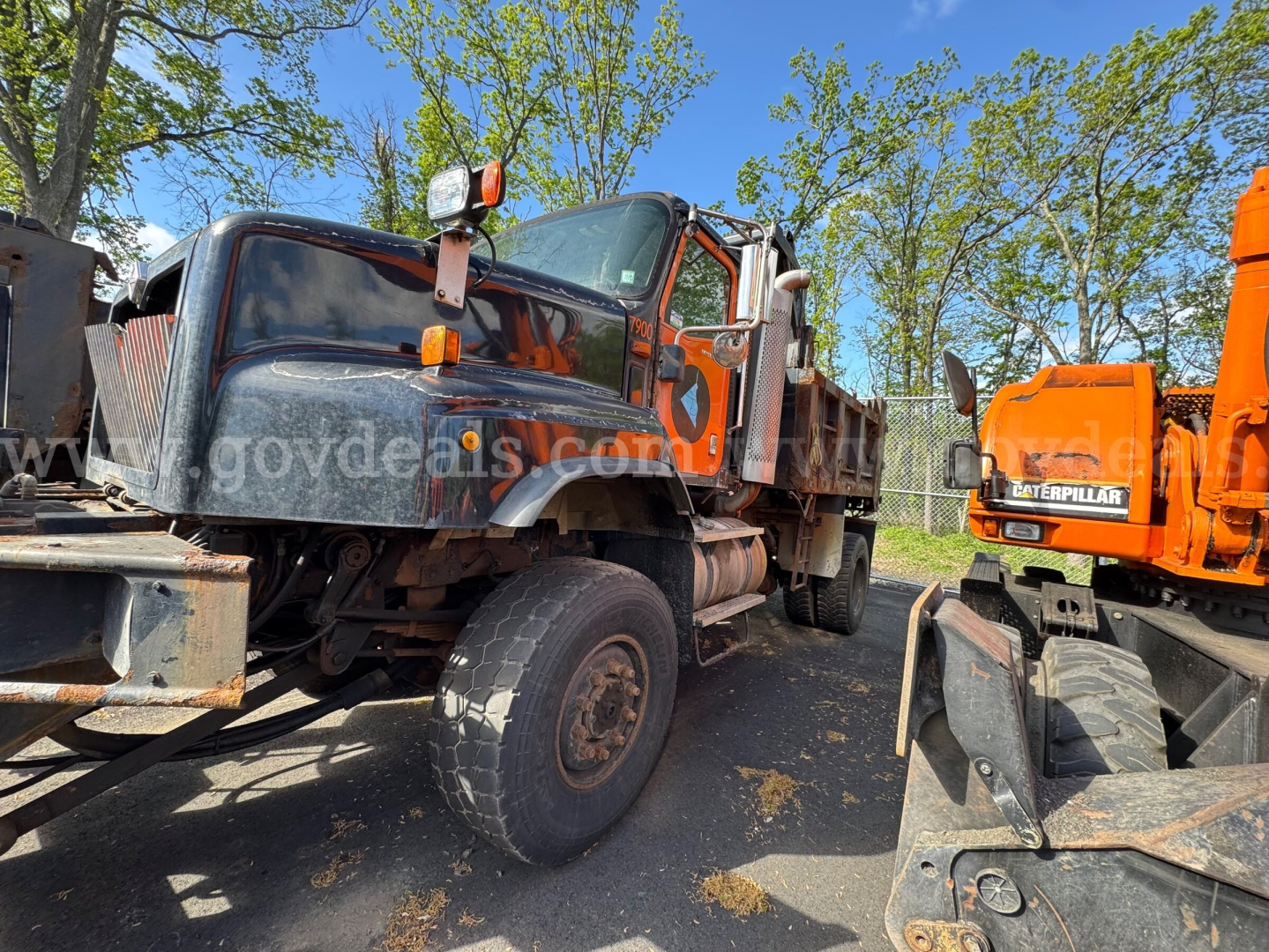 Truck chassis showing 2004 International 5600i dump truck with front-wheel tilt and exposed drivetrain parts.