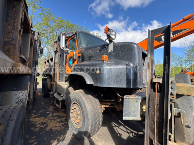 Truck body of a 2004 International 5600i dump truck showing wheel, front fender, and hydraulic bed components with visible text and labels.