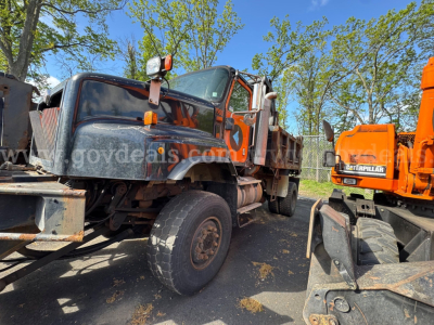 Truck chassis showing 2004 International 5600i dump truck with front-wheel tilt and exposed drivetrain parts.