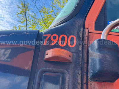 International truck side showing orange 7900 number and red-blue cab with mirror; engine bay area