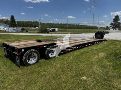Lowboy trailer showing long flatbed with wood deck and dual rear axles, Fontaine Renegade Xn20 style identification not visible.