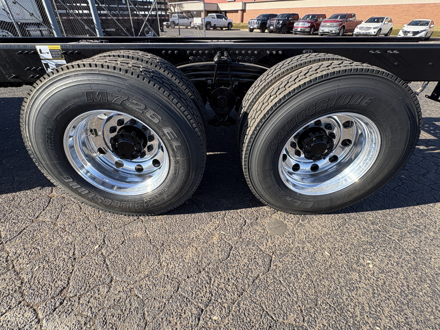 Dual rear wheels showing MXS brand tires and polished chrome rims on a Mack GR64B chassis side view.