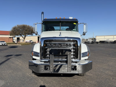 Front view of a Mack GR64B truck showing chrome grille, large bumper, and winch equipment. Visible text includes MACK on grille.