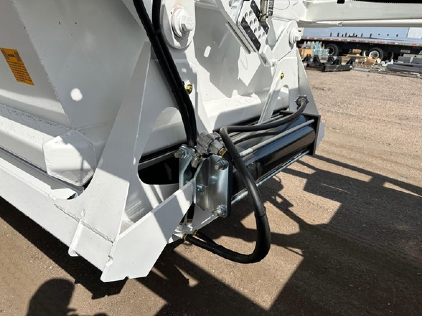 Bottom dump trailer hitch area with hydraulic hoses and mounting brackets visible
