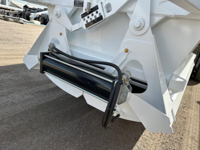 Bottom dump trailer rear view with hydraulic hoses and mounting hardware, white paint, and reinforced hitch area.
