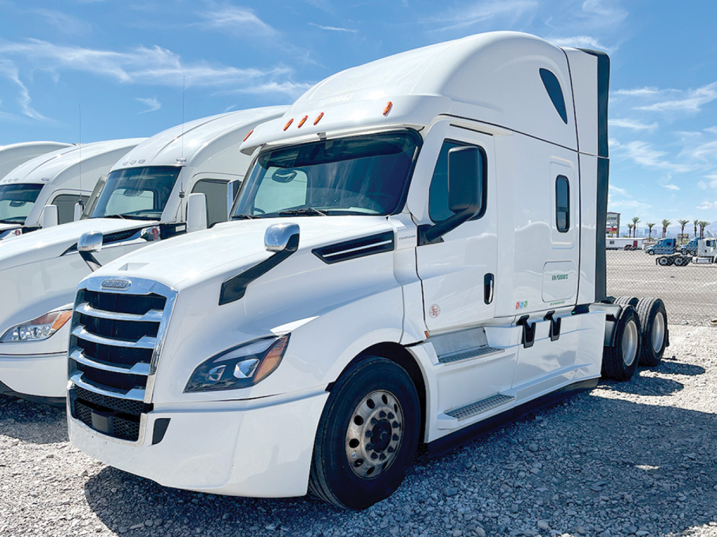 Freightliner Cascadia126 sleeper cab tractor in white, front-left view showing large grille, hood, side mirrors, and aerodynamic top fairing; image likely from a used truck lot.