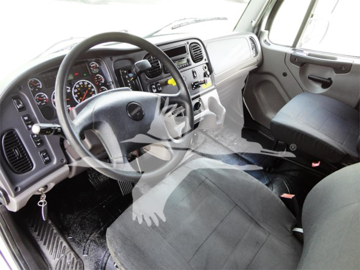 Freightliner M2 106 truck cabin interior with steering wheel and dashboard, driver seat visible.