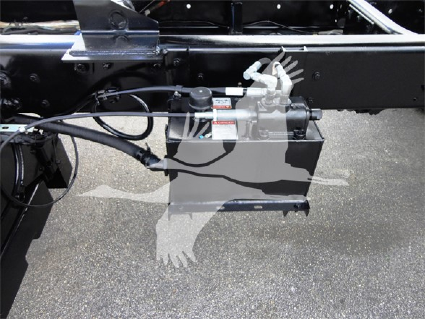 Freightliner M2 106 chassis side showing hydraulic reservoir and hoses with fittings.