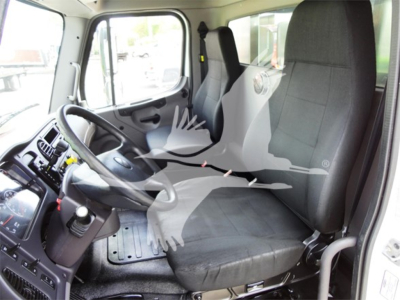 Truck cab interior showing driver seat and passenger seat with steering wheel, dashboard, and pedals in a Freightliner M2-106 cabin.
