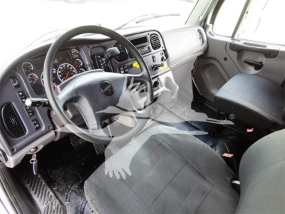 Freightliner M2 106 truck cabin interior with steering wheel and dashboard, driver seat visible.