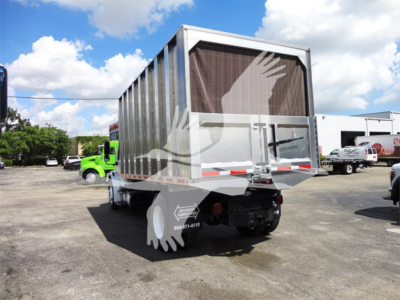 Rear view of a 2014 Freightliner M2 106 chipper body on a truck chassis with a large gray dumpster-style bed, white reflective tape, and tail components visible.