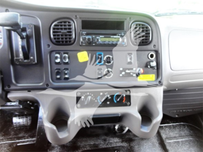 Dashboard of a Freightliner M2 106 truck cabin with multiple switches, gauges, and air vents. Center console shows control panel and radio area.