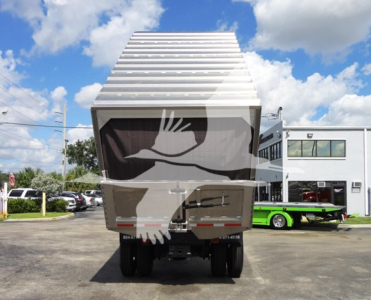 Rear view of a 2014 Freightliner M2 106 dump truck showing the bed raised and the dual rear wheels
