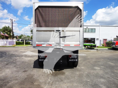 Rear view of a Freightliner truck with a dump bed, showing taillights, reflective strips, and a folded tailgate.