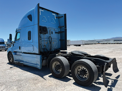Freightliner Cascadia truck tractor cab and rear chassis with fifth wheel removed, side view showing rear wheels and blue cab.
