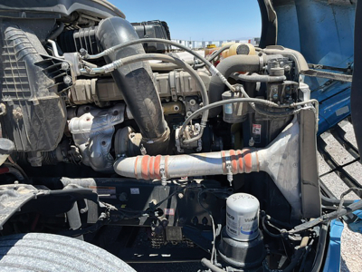 Freightliner Cascadia 126 engine bay showing turbocharger, intake hoses, and various hydraulic lines.