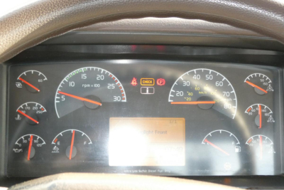 Dashboard of a Volvo VNM42T truck showing multiple gauges and warning lights