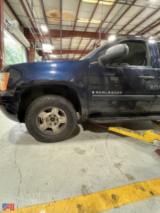 Chevrolet Avalanche pickup truck side view showing front left wheel and 'Avalanche' badge on door in a service shop bay.