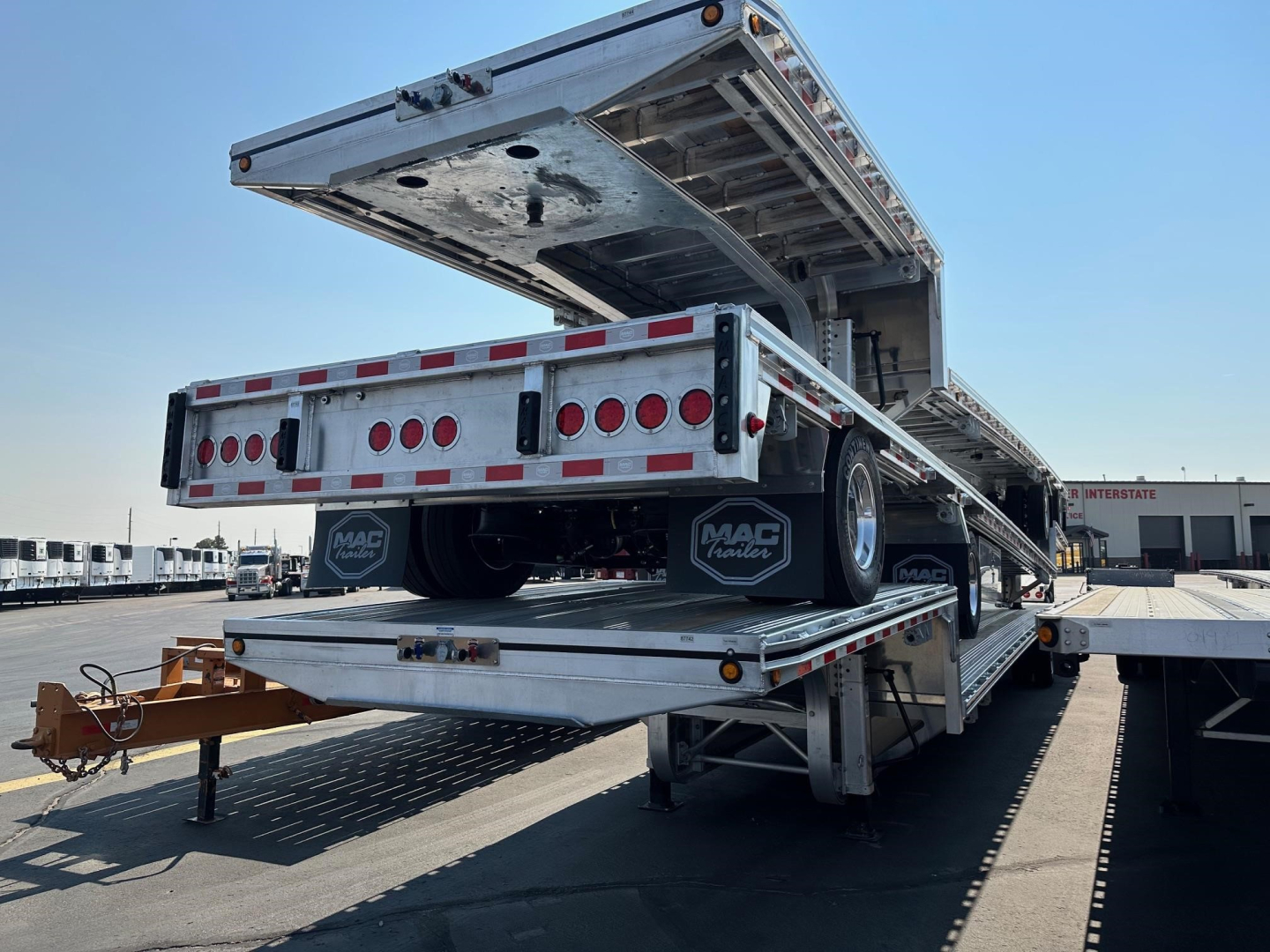 Mac drop deck trailer showing rear and lowered deck with taillights and Mac trailer mud flaps.